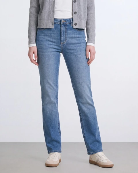On-model product photo: blue jeans and cream sneakers, crop
